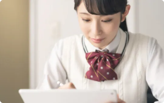 学生服を着た女の子が勉強している写真