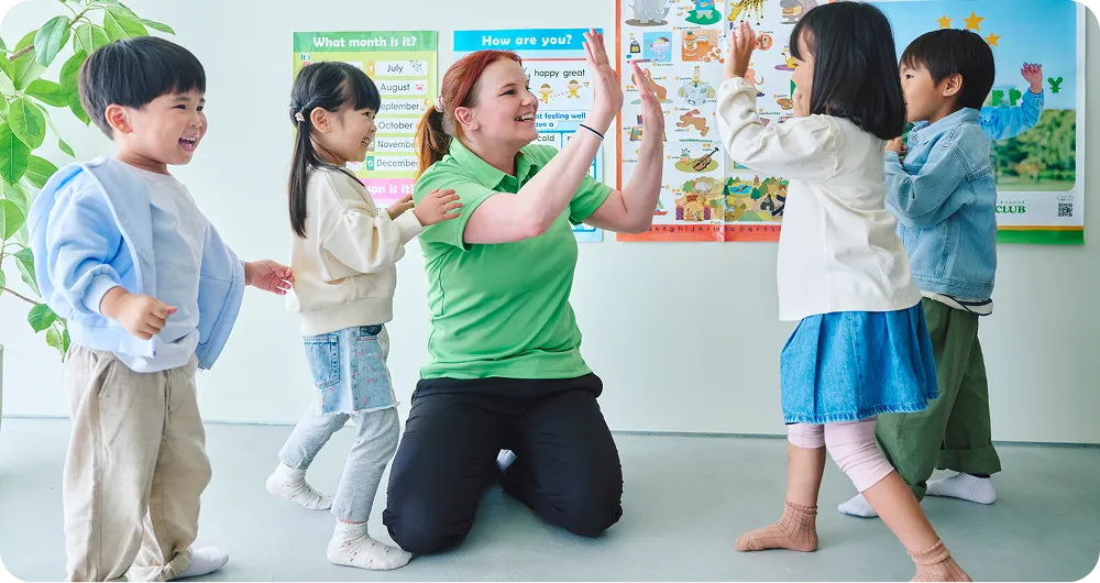 講師とハイタッチをする子どもたちの写真