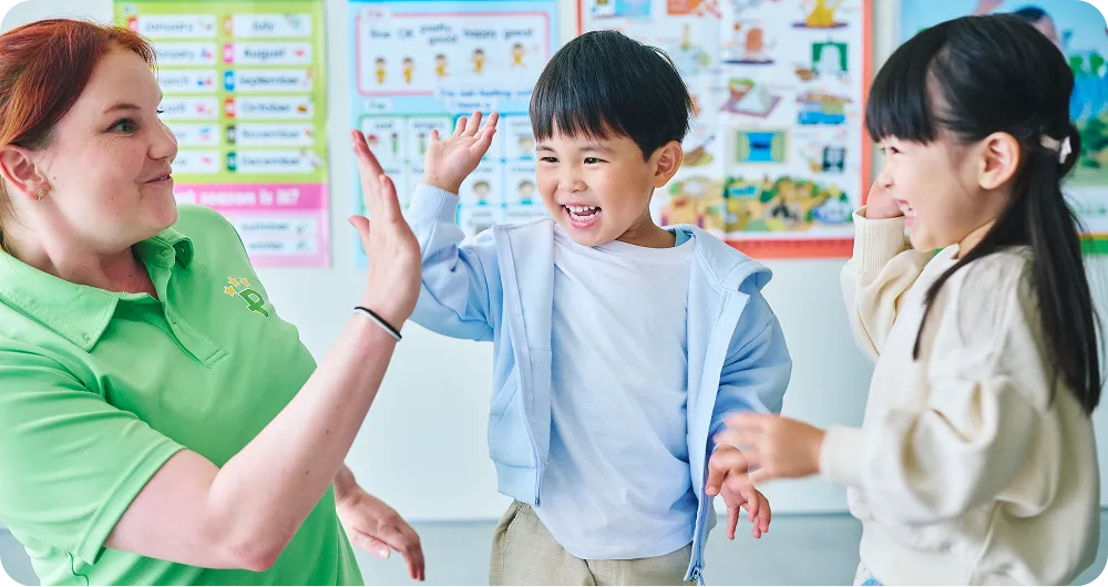 講師とハイタッチをする子どもたちの写真