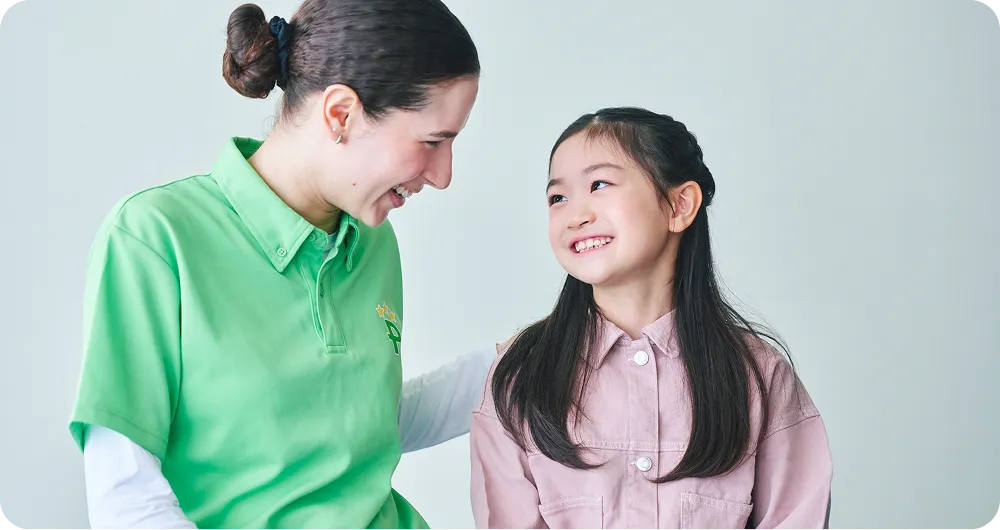 外国人講師と触れ合う女の子の写真